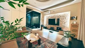 a living room with a couch and a tv at 禾夏民宿Her Shot Inn in Hengchun South Gate
