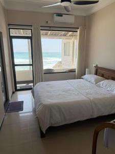 a bedroom with a bed and a view of the ocean at Pelican Ahangama in Ahangama