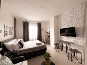 a bedroom with a bed and a table and a television at BES Building in Dasmariñas +21 photos