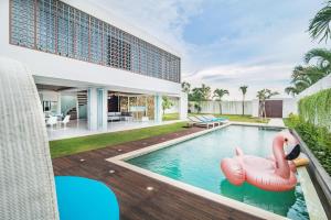 an outdoor swimming pool with an inflatable flamingo in a house at Villa Kamag Seminyak in Seminyak