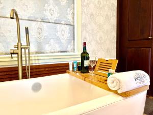 a bath tub with a bottle of wine and two glasses at Nicholas Cottage in Nuwara Eliya
