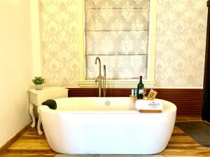 a white bath tub in a bathroom with a window at Nicholas Cottage in Nuwara Eliya +32 photos