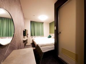 a hotel room with a bed and a mirror at Hotel Areaone Naruto in Naruto