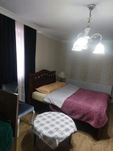 a bedroom with a bed and a chair and a chandelier at Boutique hotel in Poti