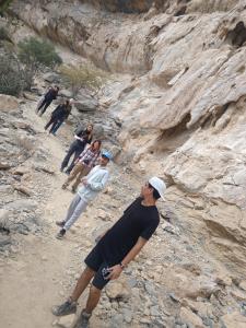 a group of people standing on a rocky mountain at house of the cloud jabal shams in Sa‘ab Banī Khamīs