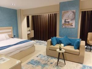 a bedroom with a bed and a couch and a chair at MIRA Holiday Home in Cairo