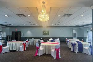 a banquet hall with tables and chairs and a chandelier at Quality Inn & Suites Lehigh Acres Fort Myers in Lehigh Acres +53 photos