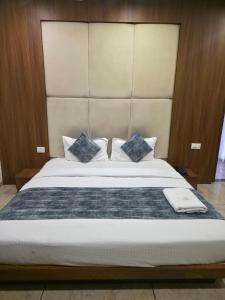 a bedroom with a large bed with blue pillows at Hotel Right Choice in Indore