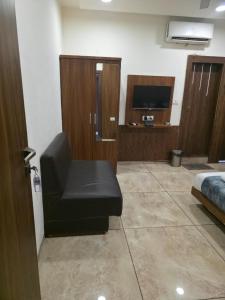 a living room with a black chair and a television at Hotel Right Choice in Indore