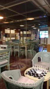 a restaurant with chairs and tables and a table with a chessboard at Hotel The Enchanted Residence in Dhaka