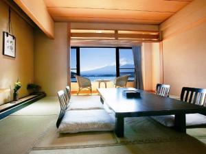 a living room with a dining room table and chairs at Shuhokaku Kogetsu in Fujikawaguchiko