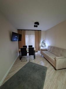 a living room with a couch and a table and a christmas tree at Apartament OLIWIA 5 in Nowy Targ
