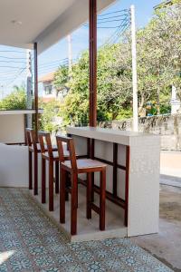 a kitchen with a counter with chairs and a table at Coasta Wings Hostel in Nathon Bay