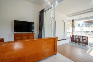 a living room with a flat screen tv on a dresser at Coasta Wings Hostel in Nathon Bay