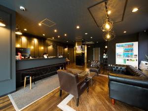 a living room with couches and a bar in a building at Hotel Areaone Naruto in Naruto
