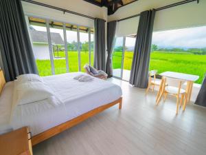 a bedroom with a bed and a table and chairs at บ้านผ่อดอยกอยดาวพรีเมี่ยม in Ban Sop Nong