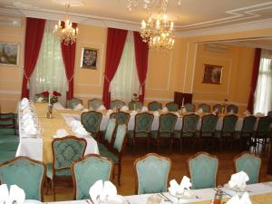 una sala de conferencias con mesas, sillas y lámparas de araña en Penzion Gostilna Keber, en Domžale