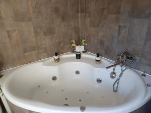 a large white bath tub in a bathroom at Cap Vosges 3 étoiles, Jeux et Balnéo, entre Vosges et Alsace in Plainfaing +41 photos