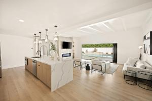 a white kitchen and living room with a table at Private Pool Escape Casita Mini Golf 4BR in Indio