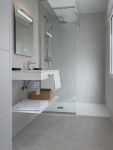 a white bathroom with a sink and a shower at 6 de Mayo alojamientos in Almansa