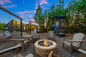 a patio with chairs and a fire pit and a playground at Spa Game Room Sunset Views 5BR Cabin in Broken Bow