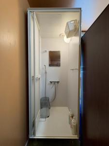 a bathroom with a shower with a glass door at 駅本ビル民宿4階 in Yuzawa +59 photos