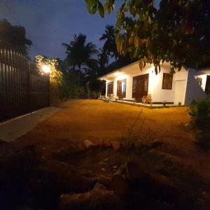 a house lit up at night with a yard at Ashan Villa Ahungalla in Ahungalla