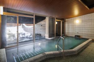 a swimming pool in a building with a tub at Hakuba Tokyu Hotel in Hakuba +94 photos