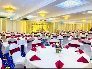 a large banquet hall with white tables and red napkins at Hotel East Lagoon in Batticaloa +82 photos
