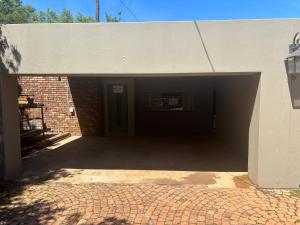 an empty garage with a door in a brick building at Buchan's corner Unit 1 in Hartbeespoort +4 photos
