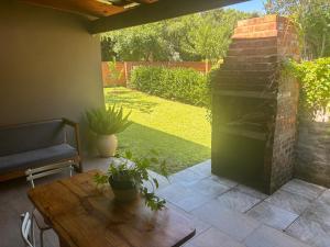 a patio with a fireplace and a wooden table at Buchan's corner Unit 1 in Hartbeespoort