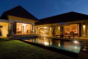 a villa with a swimming pool at night at Villa Kama in Rawai Beach