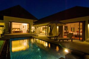 a villa with a swimming pool at night at Villa Kama in Rawai Beach +5 photos