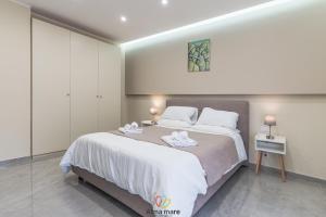 a bedroom with a large bed with two towels on it at Alma Mare in Crotone
