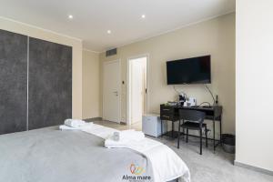 a bedroom with a bed and a desk and a tv at Alma Mare in Crotone
