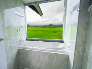 a bath tub with a window with a view of a field at บ้านผ่อดอยกอยดาวพรีเมี่ยม in Ban Sop Nong +37 photos