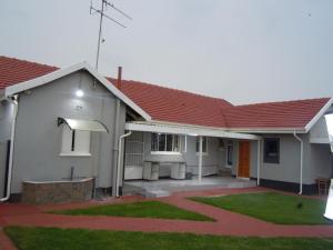 a house with a red roof and a courtyard at Daeka Guesthouse in Kempton Park