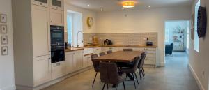 a kitchen with a wooden table and some chairs at Willow in Clifden