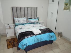 a bedroom with a bed with two towels on it at Daeka Guesthouse in Kempton Park