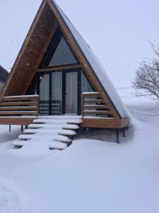 a cabin with a triangular roof in the snow at Aurora Cottage Tabatskuri Lake in Tabatsquri