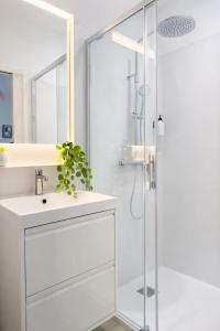 a white bathroom with a shower and a sink at La Villa Blanche Appart hôtel in Salles +91 photos