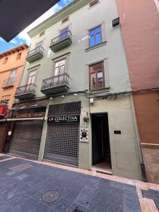 a building with a sign on the front of it at La COlectiva HOME in Xàtiva