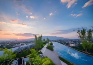 a infinity pool with a view of a city at Astra Sky River Chang Khlan Chiang Mai in Chiang Mai