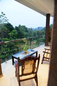 a patio with a table and chairs on a balcony at Moon Lanka Hotel Hikkaduwa in Hikkaduwa