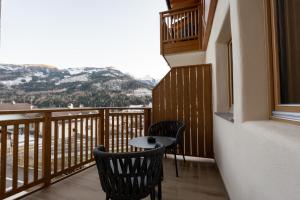 a balcony with two chairs and a table at Guest House Fleim in Panchià