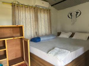 a bed in a room with an elephant picture on the wall at Hostel Jungle Beats in Sauraha