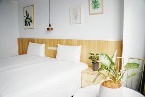 a bedroom with two beds and a table with plants at 吾庭文旅電梯民宿 WuTing Stay in Hualien City