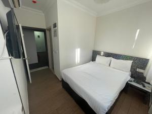 a bedroom with a white bed and a television at Grand Lavin Hotel in Antalya