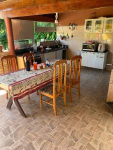 a kitchen with a table and chairs and a kitchen with a counter at Recanto Pedrita in Pedreira