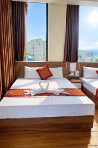 a hotel room with two beds with a large window at Ngọc Tùng Hotel in Ha Long